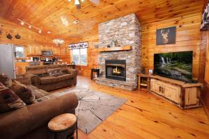 una sala de estar con una gran chimenea de piedra en una cabaña en Luxury Theatre Cabin, en Sevierville