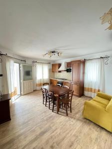 a living room with a table and a yellow couch at Budoni residence Lutturai 4 in Budoni