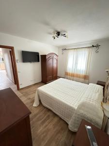 a bedroom with a bed and a flat screen tv at Budoni residence Lutturai 4 in Budoni