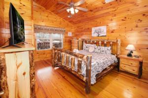 Un dormitorio con una cama en una cabaña de troncos en Luxury Theatre Cabin, en Sevierville