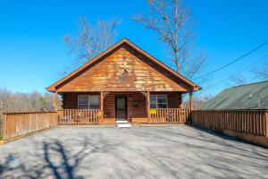 una cabaña de madera con una valla delante en Luxury Theatre Cabin, en Sevierville