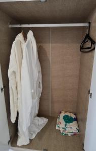 a closet with white towels and a pillow on the floor at Elisha's City Apartment in Hackbridge +18 photos