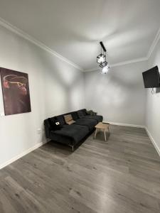 a living room with a black couch and a table at В центре апартаменты ЖК Orynbor Towers in Astana