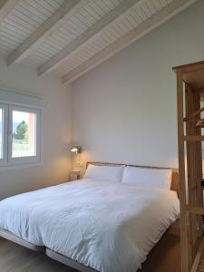 a bedroom with a large white bed with a window at La Alegria de la Huerta Cudillero in Cudillero
