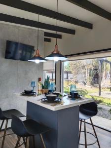 a kitchen with a island with chairs and lights at Cabaña aeropuerto 4 personas in Puerto Montt +13 photos