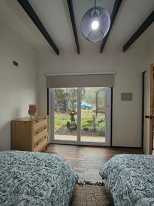 a bedroom with two beds and a large window at Cabaña aeropuerto 4 personas in Puerto Montt