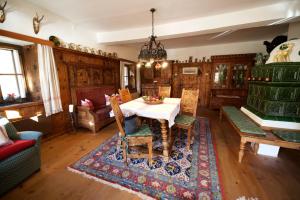 une salle à manger avec une table, des chaises et un tapis dans l'établissement Schlosshaus, à Mauterndorf