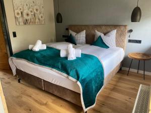a bedroom with a large bed with a green blanket at Bergidyll in Oberstaufen