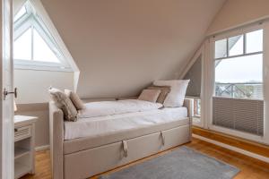 a white couch in a room with two windows at Diekhus SPO Diekhus 3 in Böhl