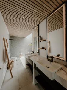a bathroom with two sinks and a large mirror at abode II Zanzibar in Paje
