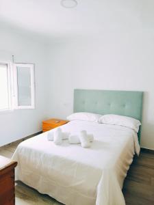 een slaapkamer met een groot wit bed met handdoeken erop bij Casa del Tío Paco in Montecorto +27 foto's