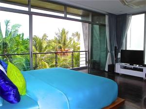 a large blue bed in a room with a balcony at Eva Villa Rawai 3 bedrooms Private Pool in Rawai Beach