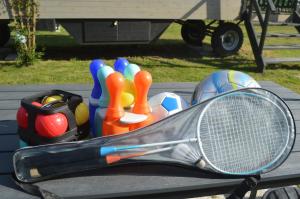 a table with a tennis racket and balls on it at L'Insolite de Nathcy in Thiel-sur-Acolin