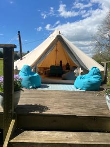 a tent with blue inflatables on a wooden deck at Swallows Oast Glamping in Sedlescombe