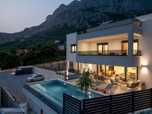 a house with a swimming pool and a mountain at Villa Bacula in Veliko Brdo