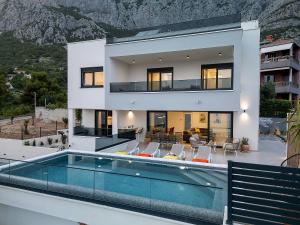 a large white house with a swimming pool at Villa Bacula in Veliko Brdo