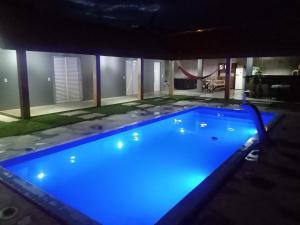 a large swimming pool with blue lighting in a house at Recanto dos Mineiros in Monte Alegre do Sul +5 photos