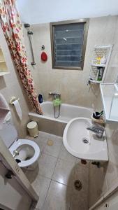 a bathroom with a toilet and a sink and a tub at 2Rooms rooftop apartment huge balcony in Tel Aviv