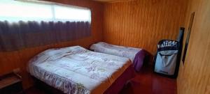 a small bedroom with two beds and a window at Casa Surf Tongoy in Tongoy
