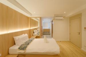 a bedroom with a white bed and a chair at Hide Nimman 2 BRS at Nimman93sqm in Chiang Mai