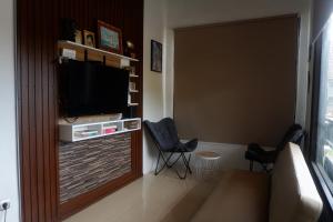 Una sala de estar con dos sillas y un televisor de pantalla plana. en Niang Hostel Penida, en Sampalan