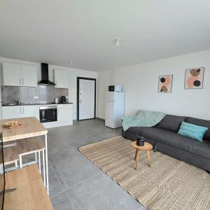 a living room with a couch and a kitchen at Urban Zen - Freneuse in Freneuse