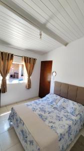 a bedroom with a bed and a window with curtains at Casa Espaço Sara Piscina Aquecimento Solar total privacidade, área gourmet completa com churrasqueira fogão a lenha, a 5min do centro e do parque das águas in São Lourenço
