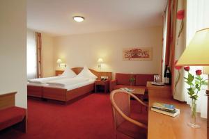 a hotel room with a bed and a desk at Haus Schwarzwaldsonne in Freudenstadt +37 photos