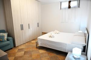 a bedroom with a bed and a cabinet and a chair at Casa Stella Marina by Bianco Puglia Vacanze in Specchiolla  +21 photos