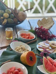 a table with bowls of fruits and vegetables on it at Villa blanca chambre d'hôtes vue sur mer in Las Terrenas