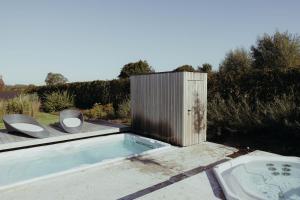 a swimming pool with two toilets and a bath tub at Au Porte Bonheur in Zwalm