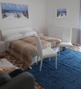 ブローロにあるEkaterina House-Grande Appartamento in Centroのベッドルーム1室(ベッド1台、白い椅子2脚付)
