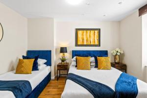2 Betten in einem Zimmer mit blauen und gelben Kissen in der Unterkunft Station 10 Beds - Contractor - Central - Sleeps 12 in Brighton & Hove
