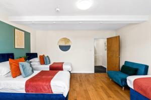 ein Hotelzimmer mit zwei Betten und einem Stuhl in der Unterkunft Station 10 Beds - Contractor - Central - Sleeps 12 in Brighton & Hove + 3 Fotos