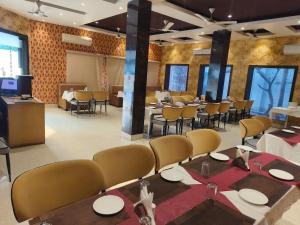 a dining room with tables and chairs in a room at Hotel The Siwan International in Siwān