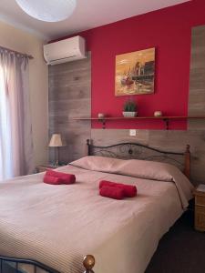 a bedroom with a large bed with two red pillows on it at Limnaria Westpark 2 bdrm apartment 122 in Paphos