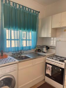 a kitchen with a sink and a washing machine at Limnaria Westpark 2 bdrm apartment 122 in Paphos