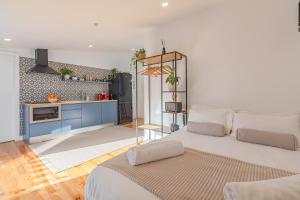 a bedroom with a large white bed and a kitchen at Casa Tamar in Lagos