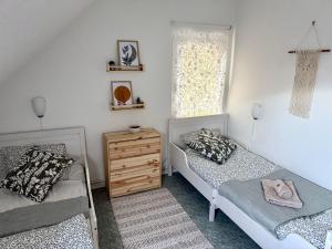 a bedroom with two beds and a dresser and a window at Katja Cottage in Bohinjska Bela