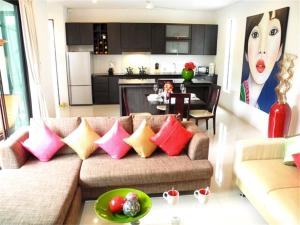 uma sala de estar com um sofá com almofadas coloridas em Intira Villa Rawai 2 bedrooms Villa em Praia de Rawai
