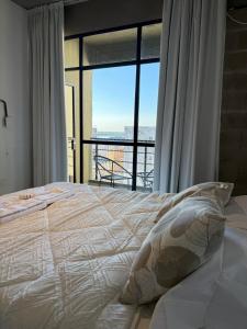 una camera da letto con un letto grande con una grande finestra di Departamento en Corrientes 3 a Corrientes