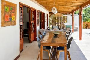 a dining room with a wooden table and chairs at Villa Tanamera in Grand-Bourg