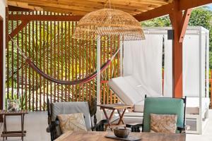 a patio with a table and chairs and a umbrella at Villa Tanamera in Grand-Bourg