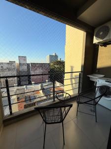 un balcone con due sedie e una grande finestra di Departamento en Corrientes 3 a Corrientes