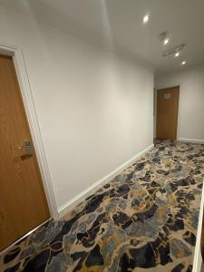 an empty room with a rug on the floor at Olympia Inn Hotel in London +12 photos
