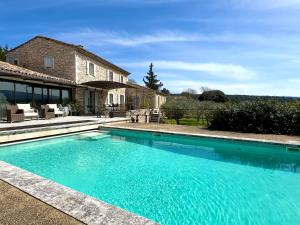 a swimming pool in front of a house at Provence km28 in Gordes