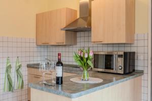 a kitchen counter with a bottle of wine and two wine glasses at Ruhige Auszeit zu zweit - Ferienwohnungen auf Usedom für Radfahrer & Strandliebhaber in Loddin +19 photos