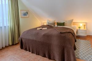 a bedroom with a large bed with a brown blanket at Ruhige Auszeit zu zweit - Ferienwohnungen auf Usedom für Radfahrer & Strandliebhaber in Loddin