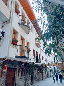 a group of people walking down a street next to a building at El Patio de Vespasiano- San Juan- vistas al ayuntamiento junto al puerto in Castro-Urdiales
