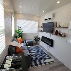 a living room with a couch and a flat screen tv at Barossa Valley Station Patio 1br Downtown in Fredericksburg